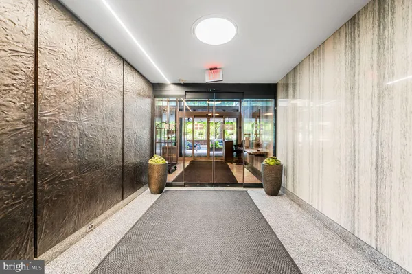 a living room with a large window and a chandelier