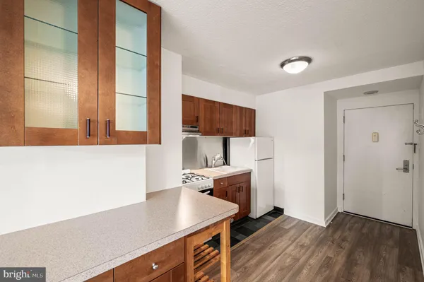 a kitchen with a sink dishwasher a stove and a refrigerator with wooden floor