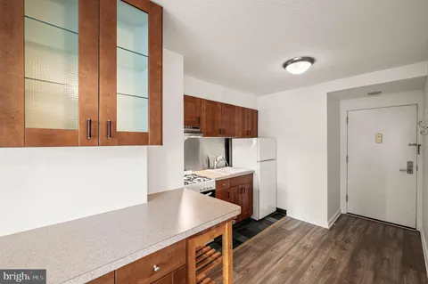 a kitchen with a sink dishwasher a stove and a refrigerator with wooden floor