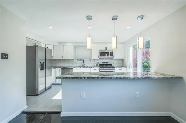 a kitchen with stainless steel appliances granite countertop a sink a stove and a refrigerator