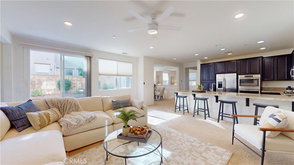 a living room with furniture kitchen and a large window