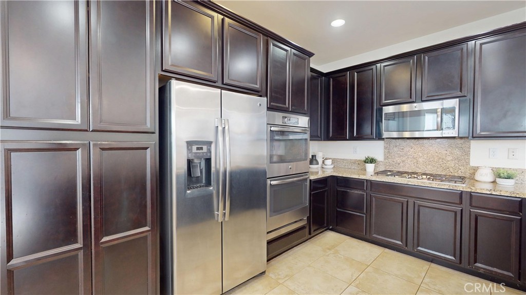 28620 Vista Del Rio Drive Valencia, CA 91354 - Photo 11 of 40 a kitchen with stainless steel appliances granite countertop a refrigerator and cabinets