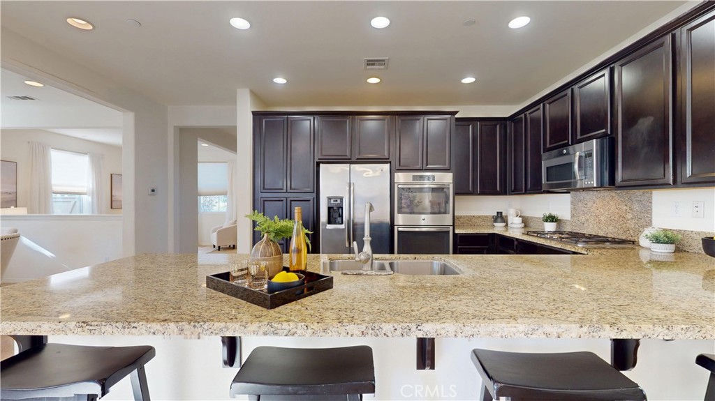 28620 Vista Del Rio Drive Valencia, CA 91354 - Photo 15 of 40 a kitchen with stainless steel appliances granite countertop a sink and a refrigerator