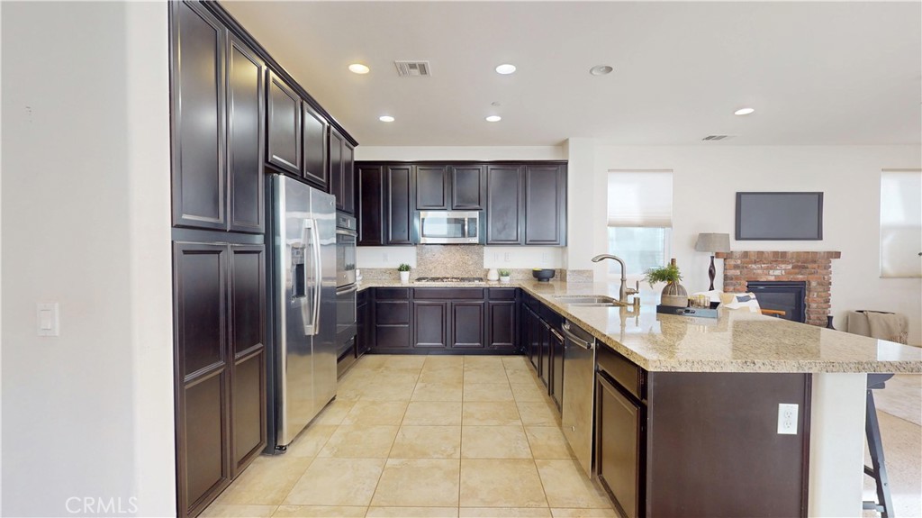 28620 Vista Del Rio Drive Valencia, CA 91354 - Photo 10 of 40 a large kitchen with stainless steel appliances granite countertop a sink refrigerator and cabinets
