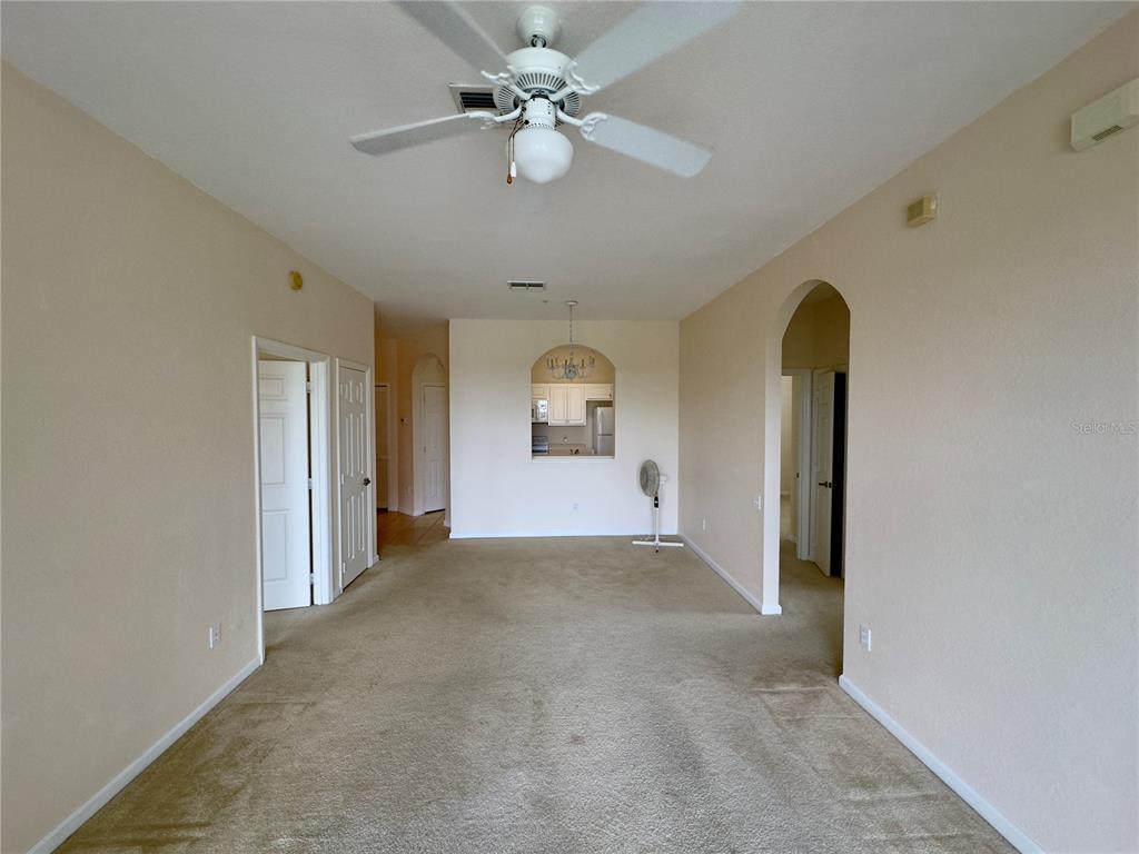 13536 Turtle Marsh Loop, Unit 532 Orlando, FL 32837 - Photo 11 of 26 an empty room with chandelier fan and windows