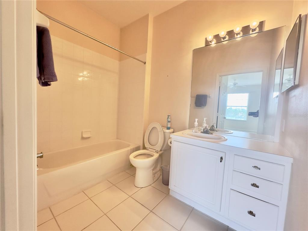 13536 Turtle Marsh Loop, Unit 532 Orlando, FL 32837 - Photo 17 of 26 a bathroom with a granite countertop sink toilet and shower