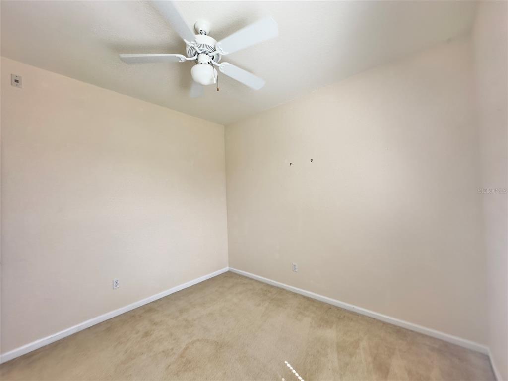 13536 Turtle Marsh Loop, Unit 532 Orlando, FL 32837 - Photo 22 of 26 an empty room with a ceiling fan and a window