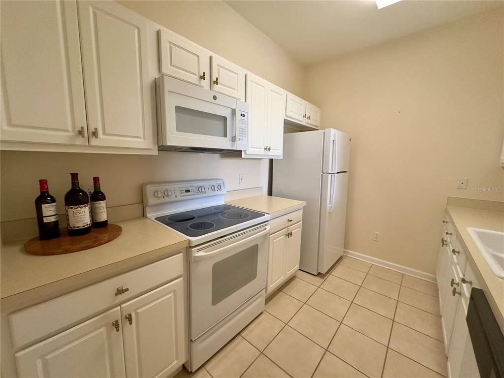 13536 Turtle Marsh Loop, Unit 532 Orlando, FL 32837 - Photo 4 of 26 a kitchen with stainless steel appliances granite countertop a sink a stove a refrigerator and cabinets
