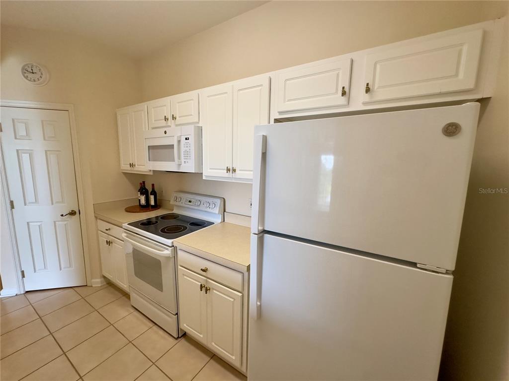 13536 Turtle Marsh Loop, Unit 532 Orlando, FL 32837 - Photo 5 of 26 a white refrigerator freezer and a stove sitting inside of a kitchen
