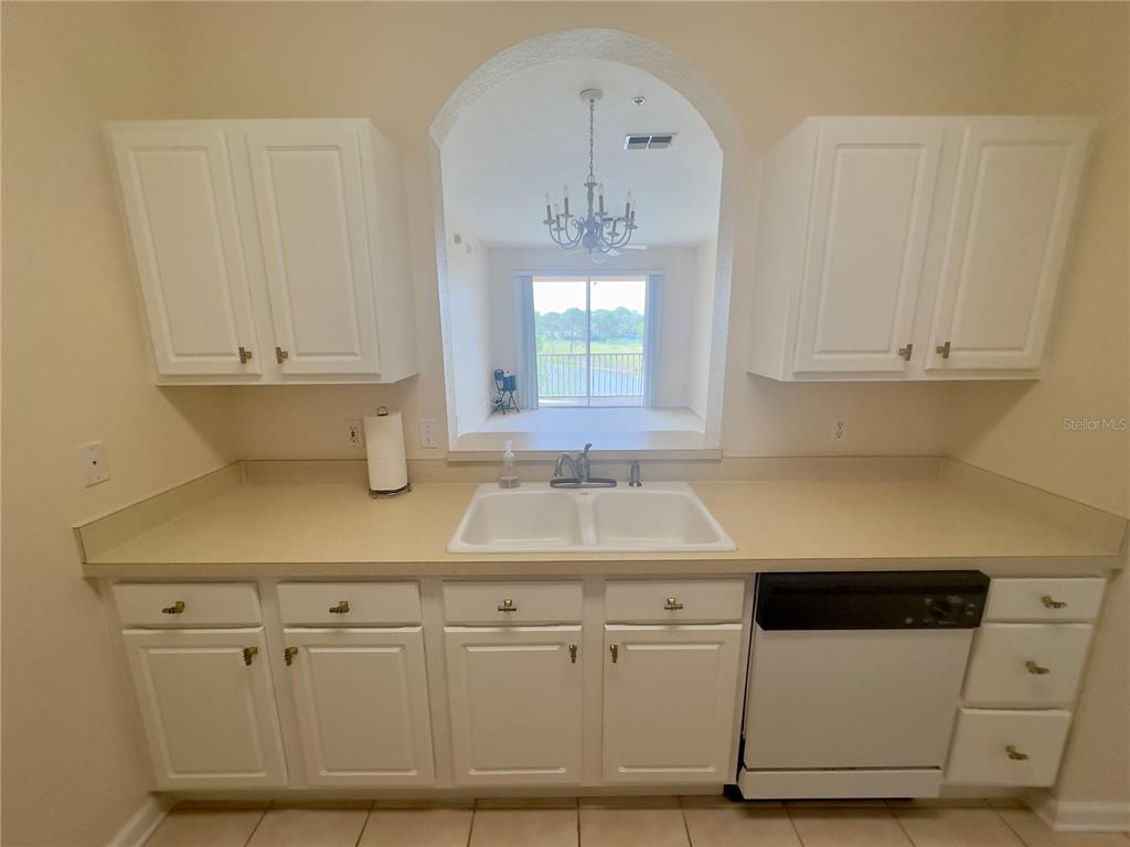 13536 Turtle Marsh Loop, Unit 532 Orlando, FL 32837 - Photo 6 of 26 a kitchen with white cabinets and sink