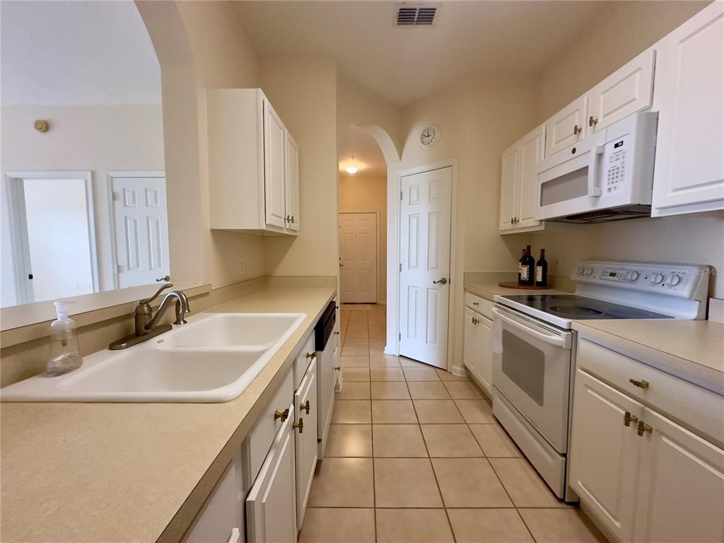 13536 Turtle Marsh Loop, Unit 532 Orlando, FL 32837 - Photo 7 of 26 a kitchen with a sink stove top oven and cabinets