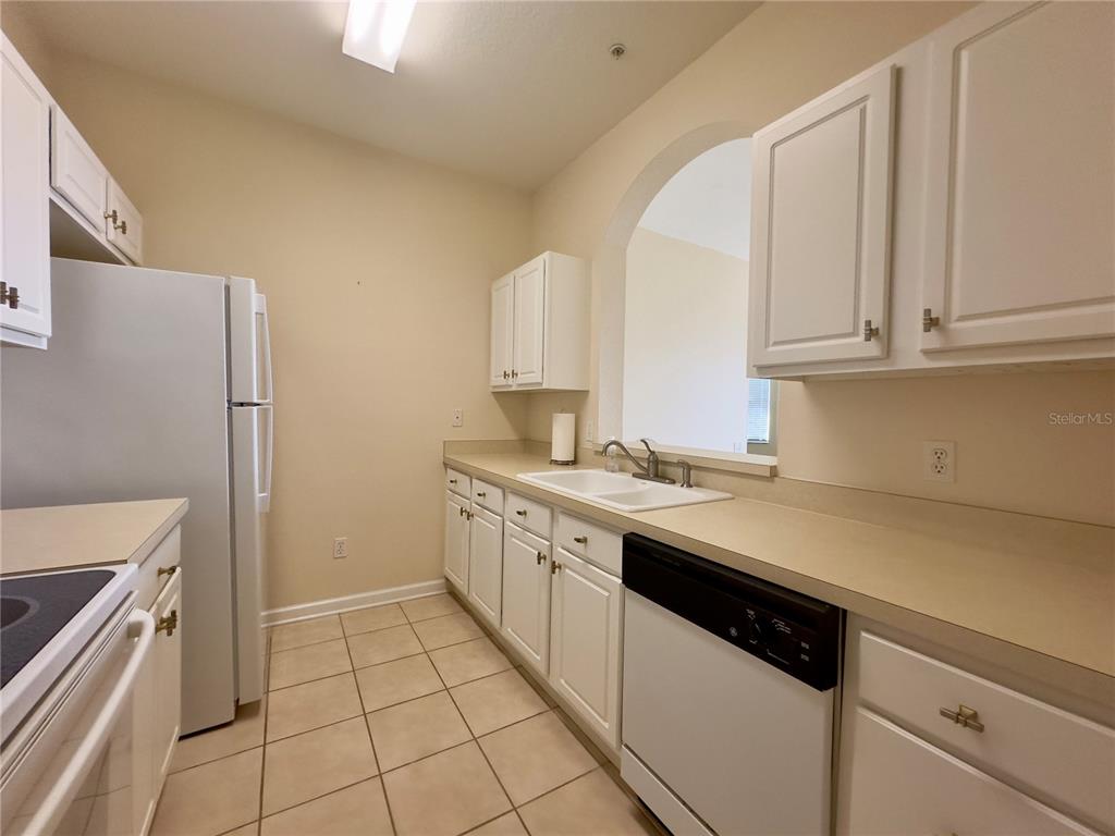 13536 Turtle Marsh Loop, Unit 532 Orlando, FL 32837 - Photo 8 of 26 a kitchen with a sink stove and cabinets