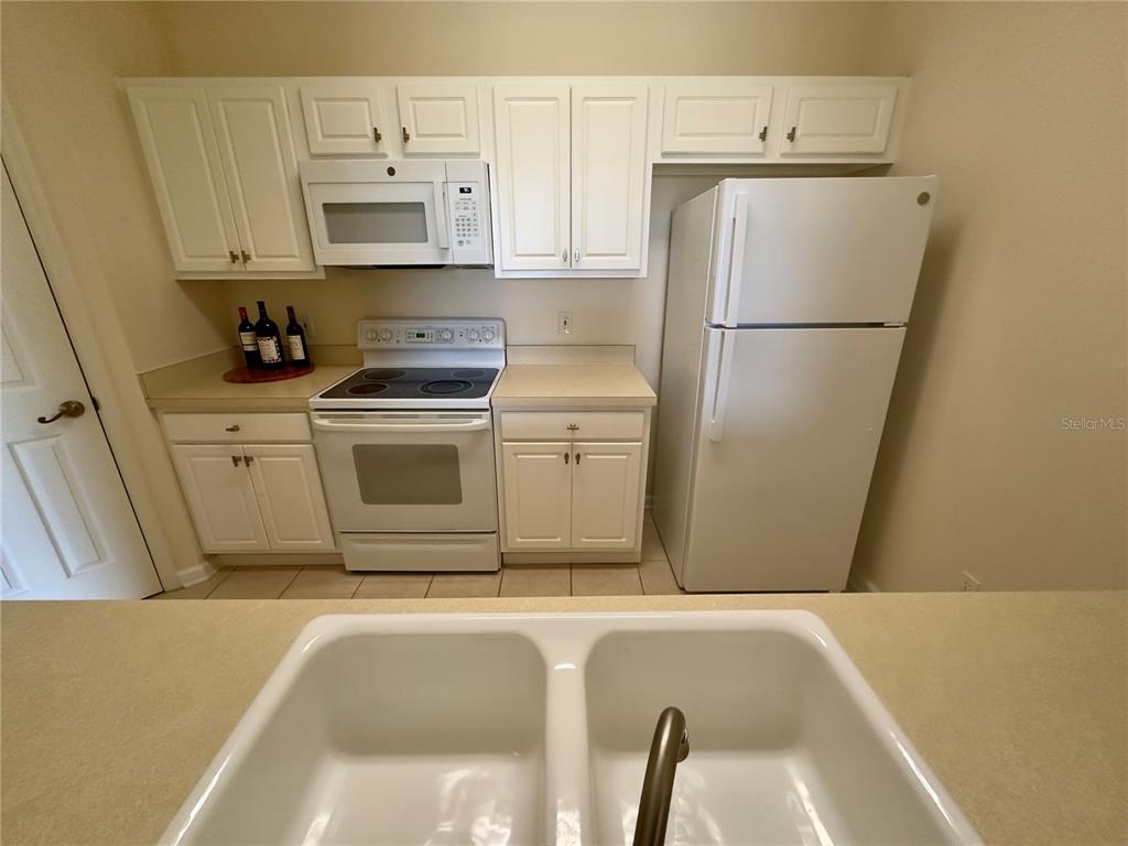13536 Turtle Marsh Loop, Unit 532 Orlando, FL 32837 - Photo 9 of 26 a white refrigerator freezer sitting inside of a kitchen