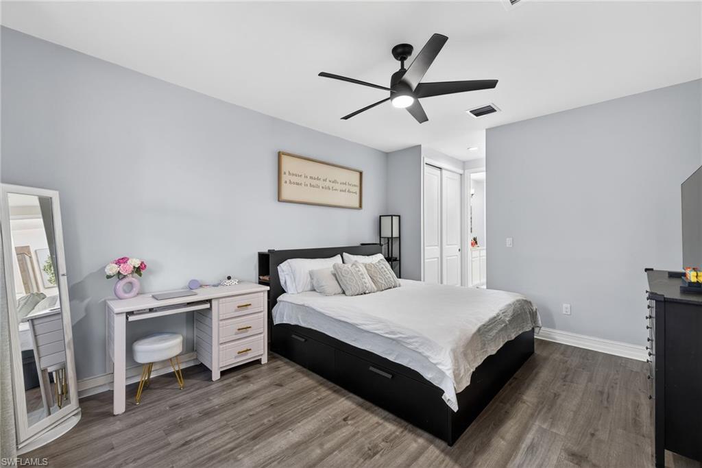 7845 Bristol Circle Naples, FL 34120 - Photo 14 of 31 a bedroom with a bed and a chandelier