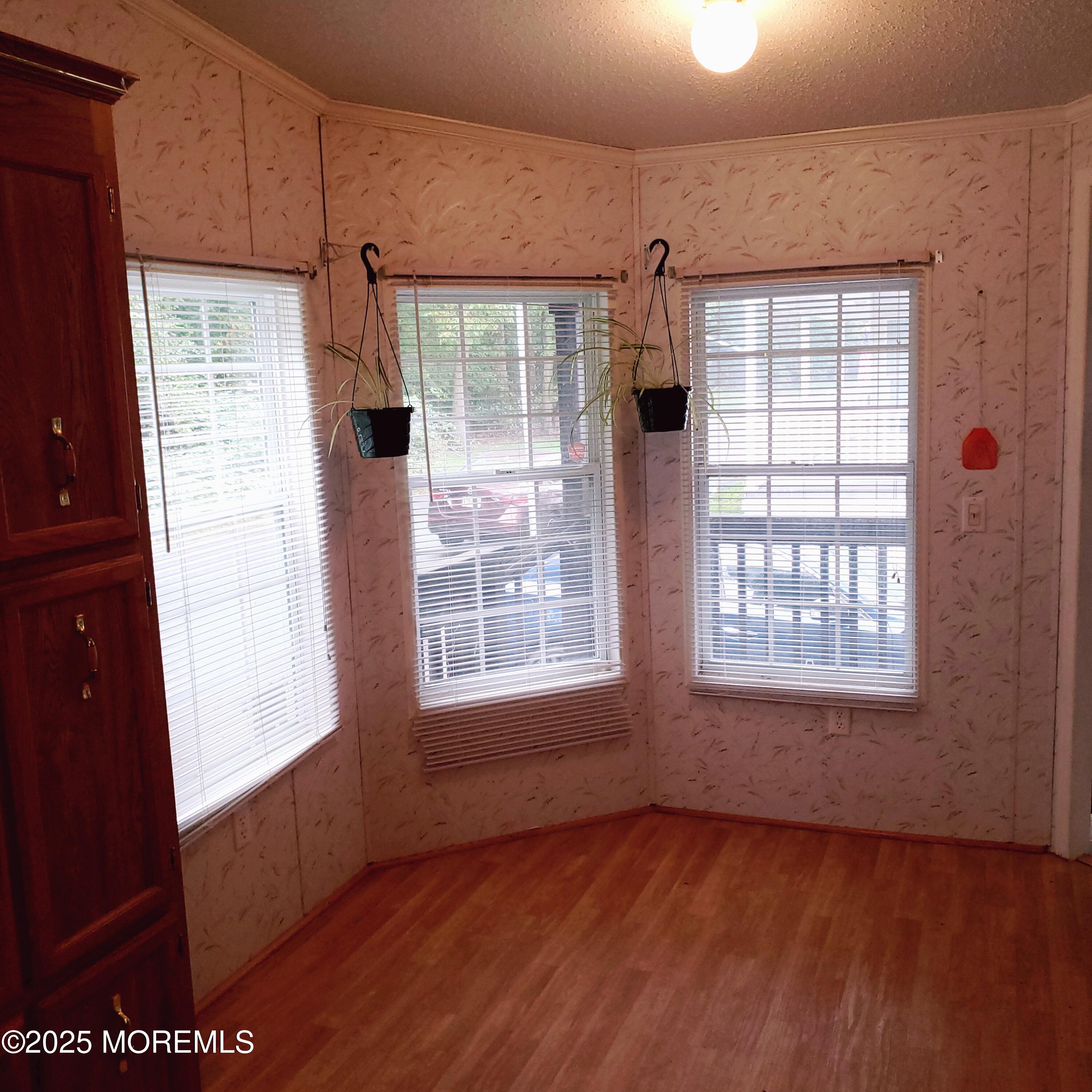 15 Village Road Morganville, NJ 07751 - Photo 3 of 12 a view of an empty room with a window and wooden floor