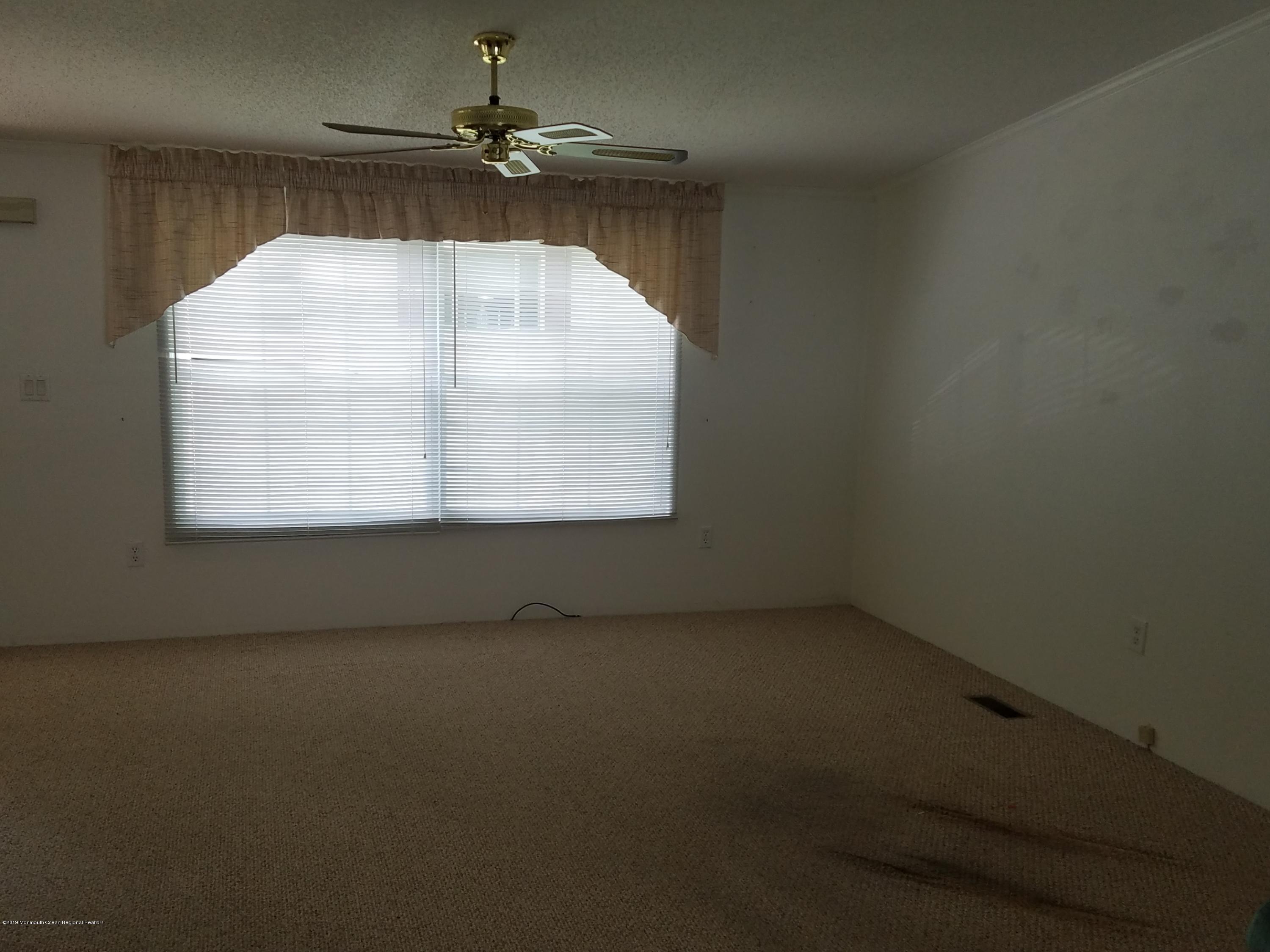 15 Village Road Morganville, NJ 07751 - Photo 5 of 12 an empty room with a empty space and a window