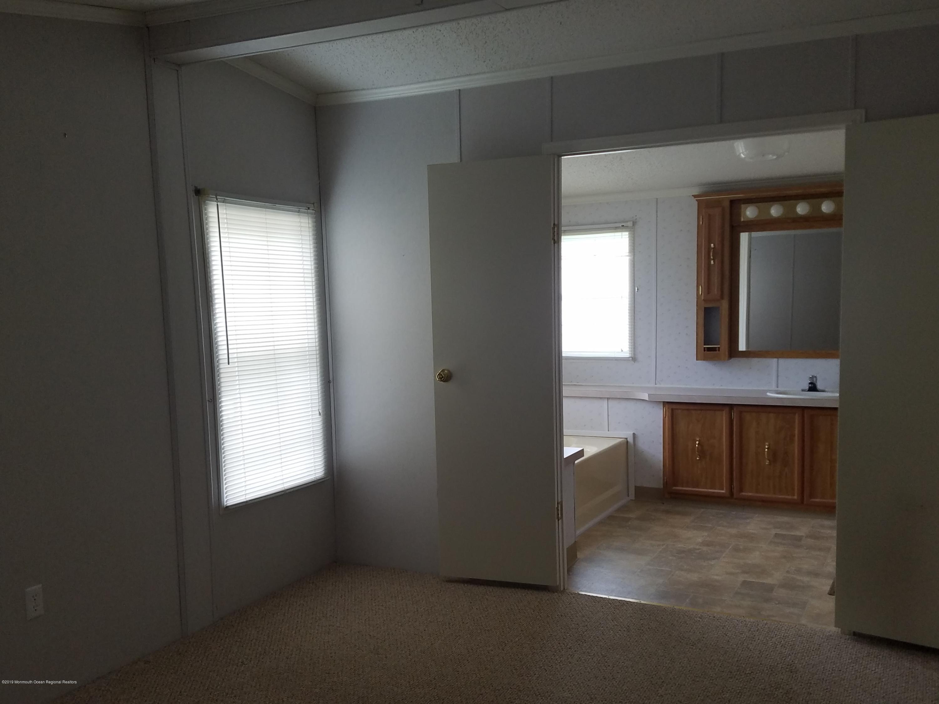 15 Village Road Morganville, NJ 07751 - Photo 8 of 12 a bathroom with a vanity and a mirror