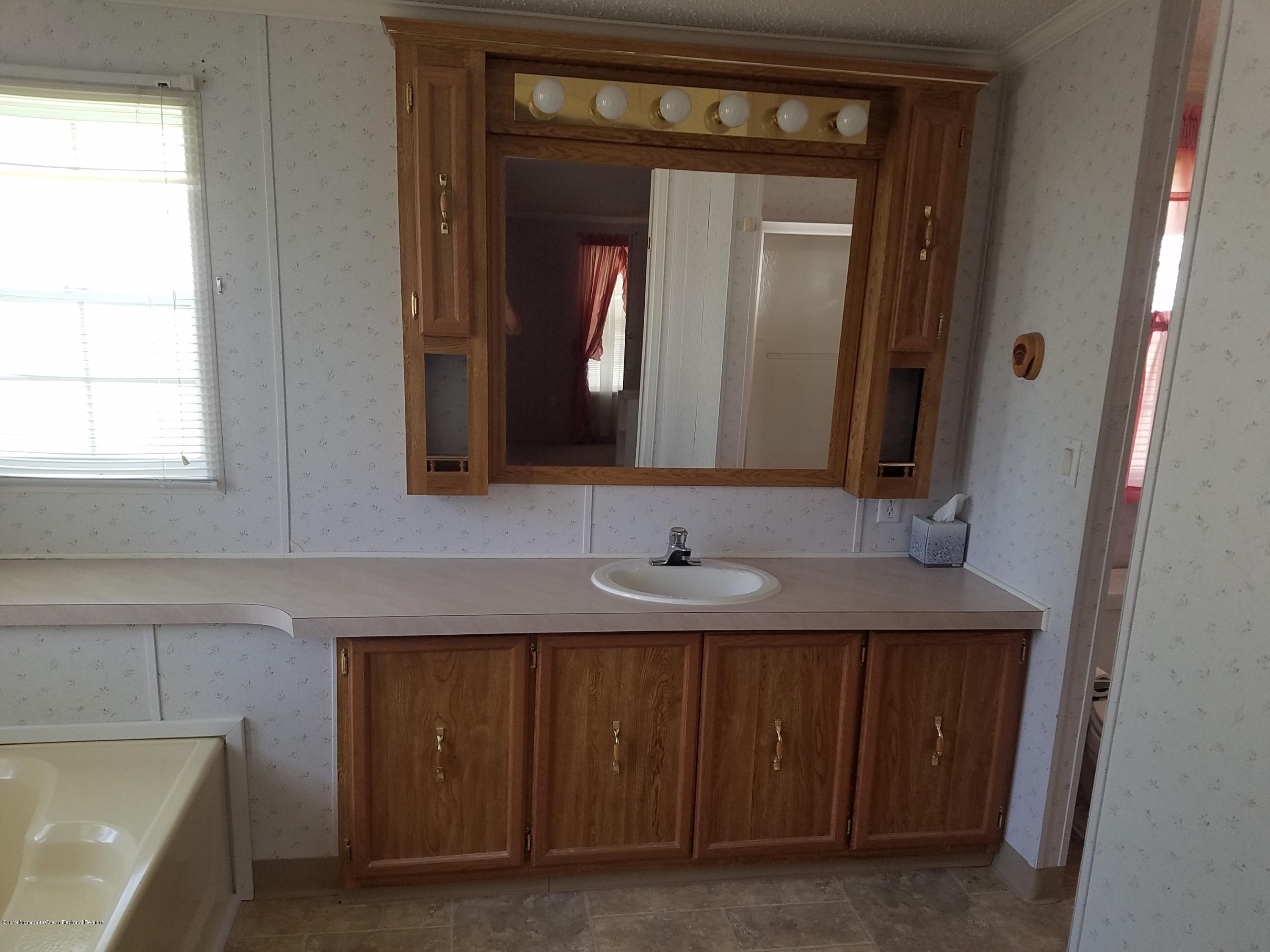 15 Village Road Morganville, NJ 07751 - Photo 10 of 12 a bathroom with a sink and a mirror