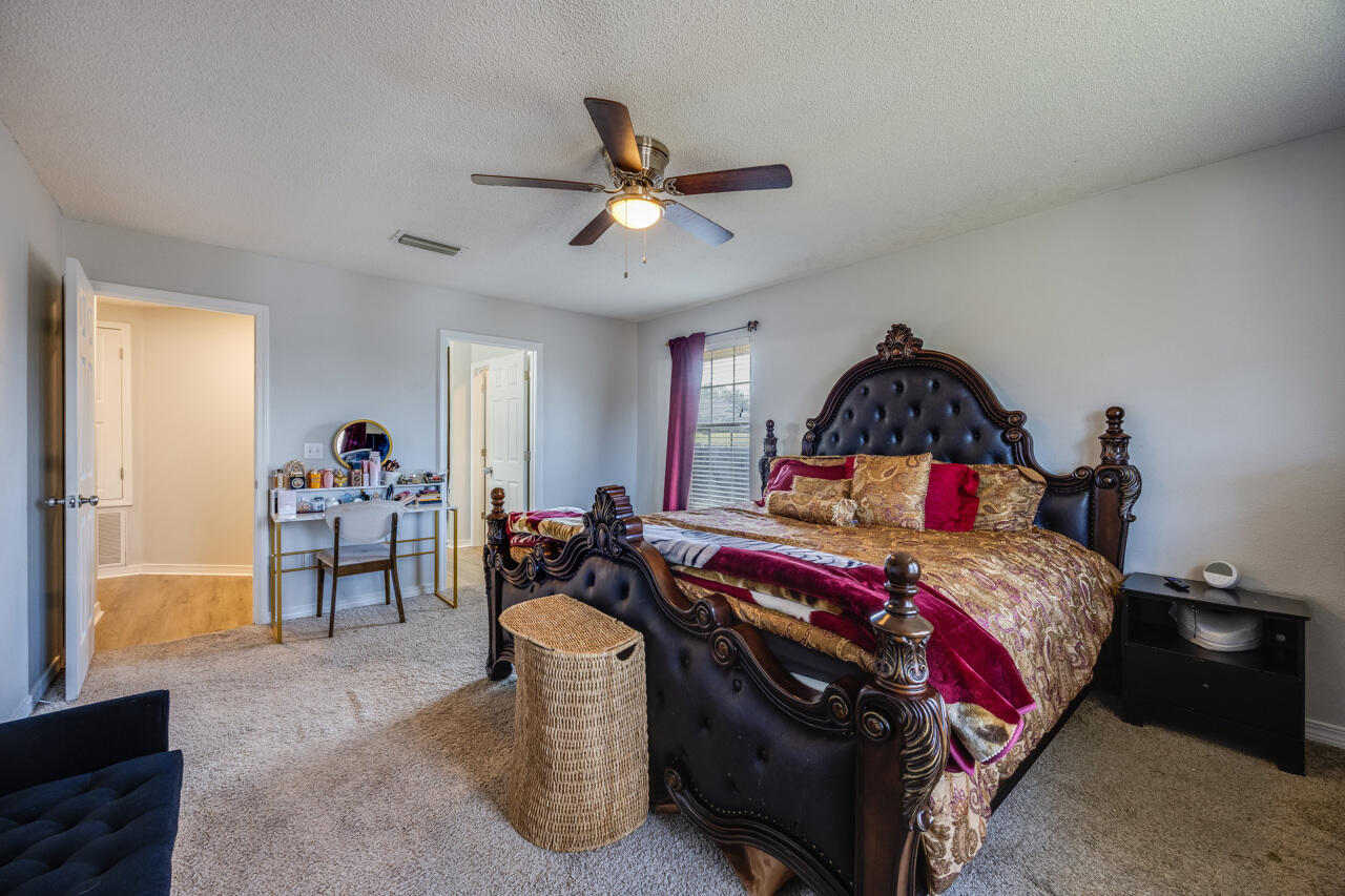 419 Triton Street Crestview, FL 32536 - Photo 33 of 60 a bedroom with a bed and a chandelier