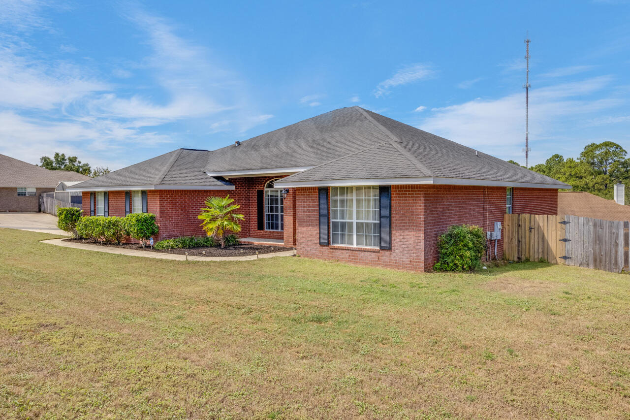 419 Triton Street Crestview, FL 32536 - Photo 4 of 60 a front view of a house with a yard and potted plants
