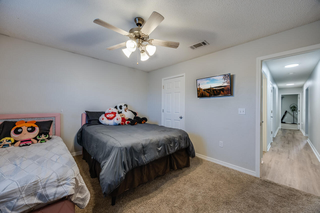 419 Triton Street Crestview, FL 32536 - Photo 44 of 60 a bedroom with a bed and a chandelier