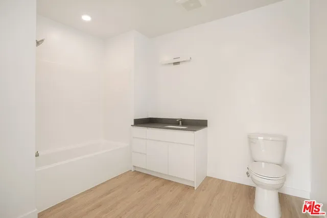 a view of a big room with wooden floor and windows
