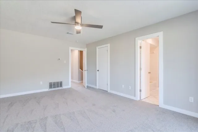 an empty room with chandelier fan