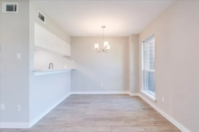a view of empty room with wooden floor and cabinet
