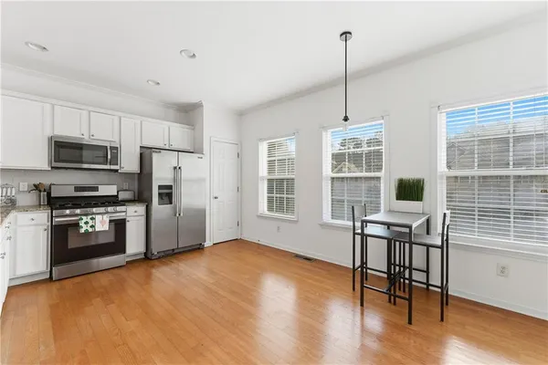 a kitchen with refrigerator cabinets and wooden floor