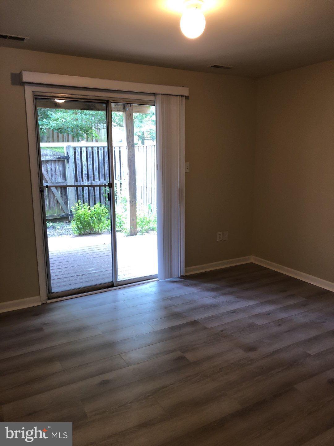 6134 Quiet Times Columbia, MD 21045 - Photo 6 of 17 a view of an empty room with wooden floor and a window