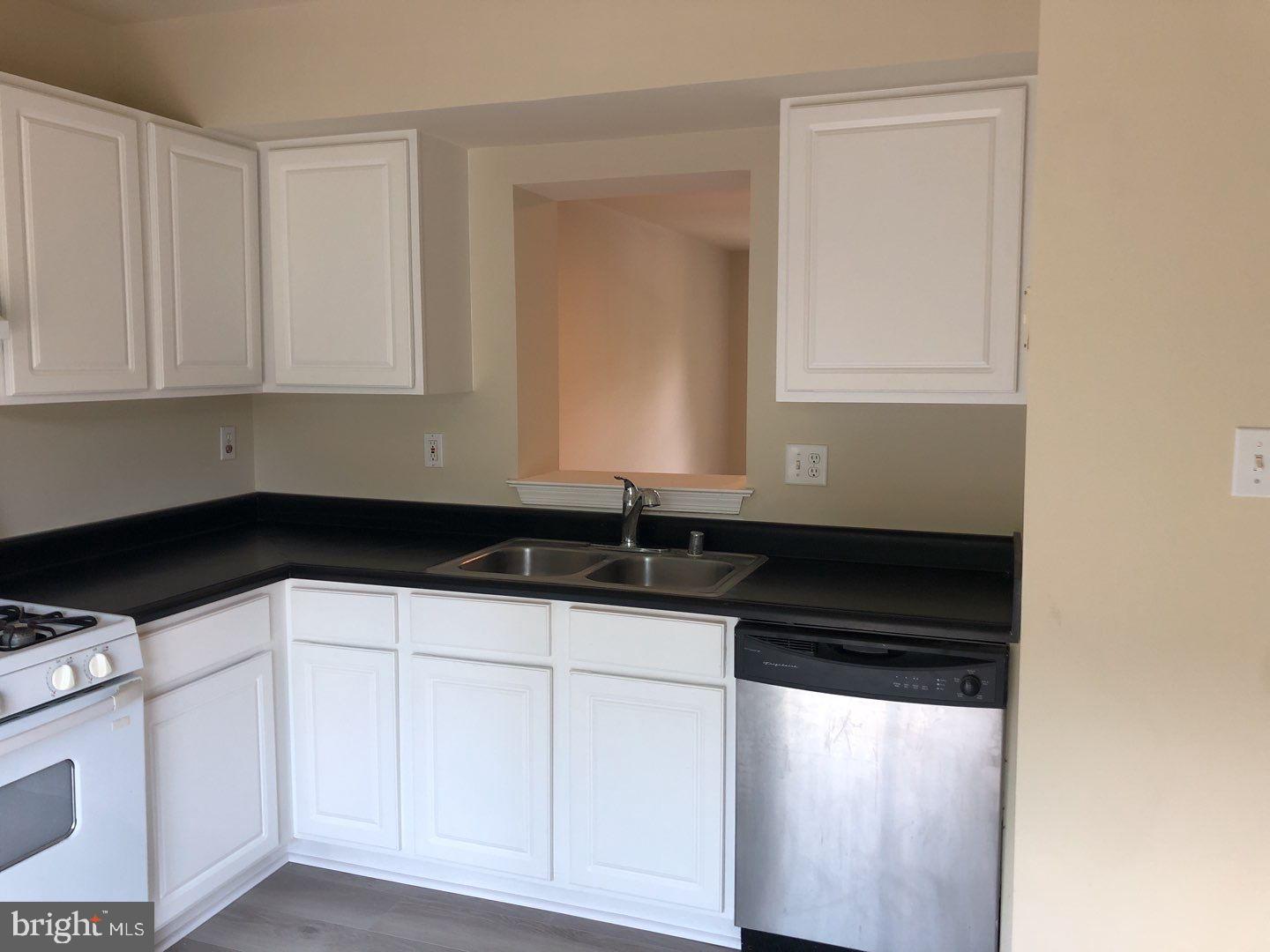 6134 Quiet Times Columbia, MD 21045 - Photo 10 of 17 a kitchen with granite countertop white cabinets and sink