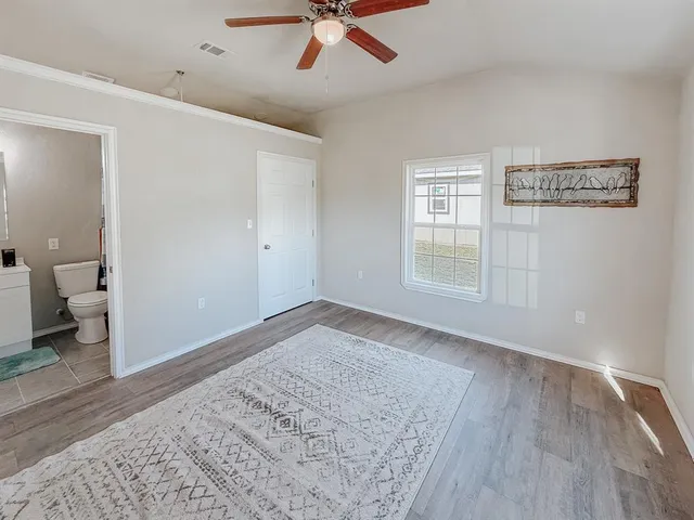 a view of a big room with wooden floor and a ceiling fan