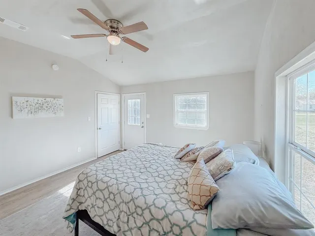 a bedroom with a large bed and a window