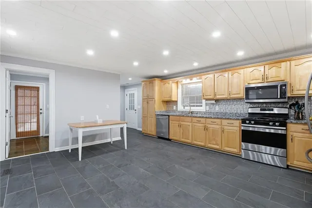 a kitchen with stainless steel appliances granite countertop a stove and a sink