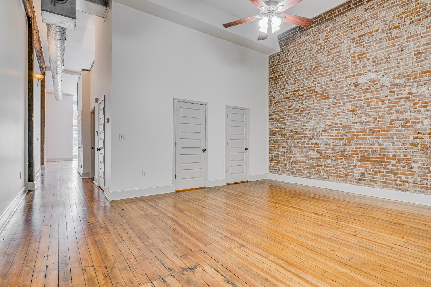 310 South Main Street, Unit 101 Memphis, TN 38103 - Photo 16 of 29 a view of an empty room with wooden floor and a ceiling fan