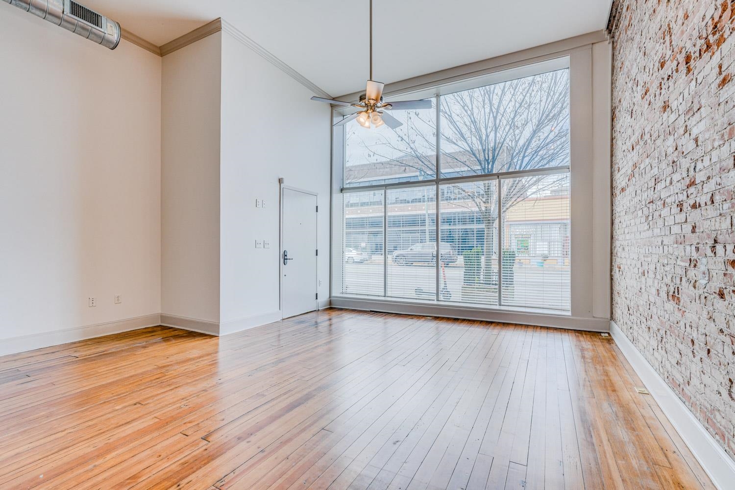 310 South Main Street, Unit 101 Memphis, TN 38103 - Photo 7 of 29 a view of an empty room with wooden floor and a window