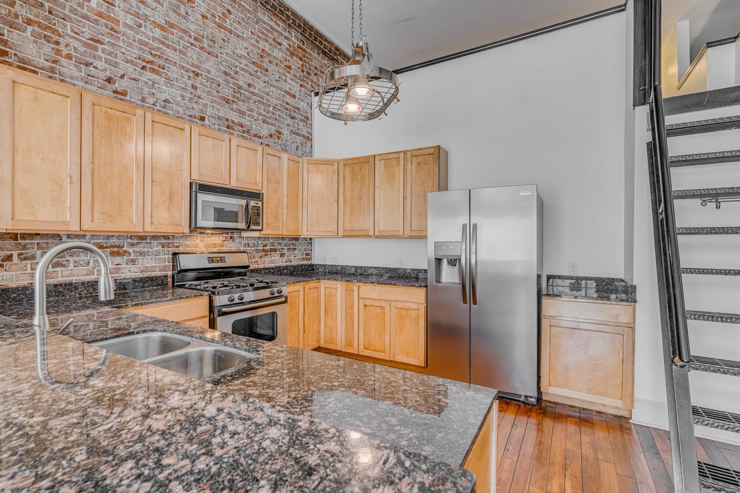 310 South Main Street, Unit 101 Memphis, TN 38103 - Photo 10 of 29 a kitchen with granite countertop a refrigerator a sink a stove a microwave and island