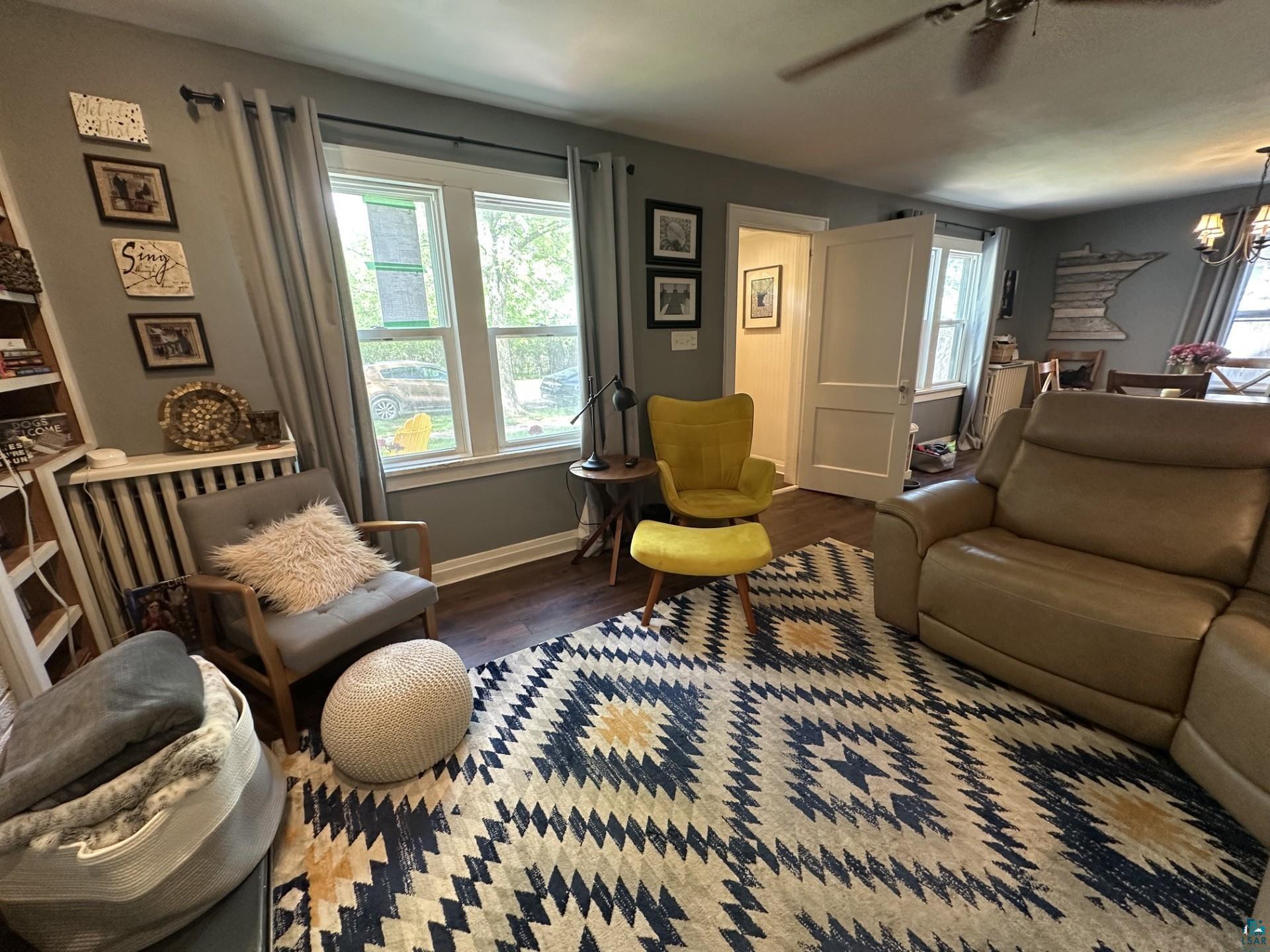 208 Chestnut Street Cloquet, MN 55720 - Photo 8 of 24 Spacious room featuring wood-finish flooring, a ceiling fan, and multiple windows with trim