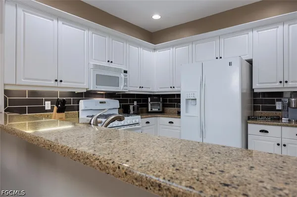 a kitchen with granite countertop a sink white cabinets and a granite counter tops