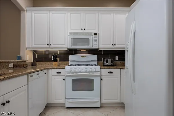 a kitchen with stainless steel appliances granite countertop a stove and a refrigerator