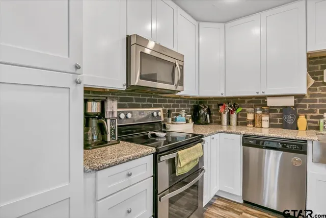 a kitchen with granite countertop a stove sink and cabinets