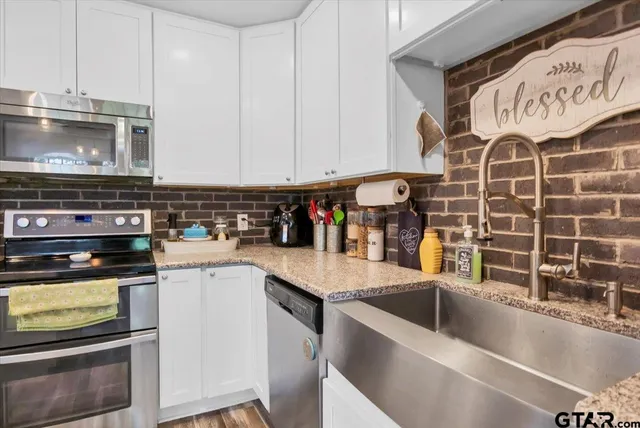 a kitchen with stainless steel appliances granite countertop a sink stove and cabinets