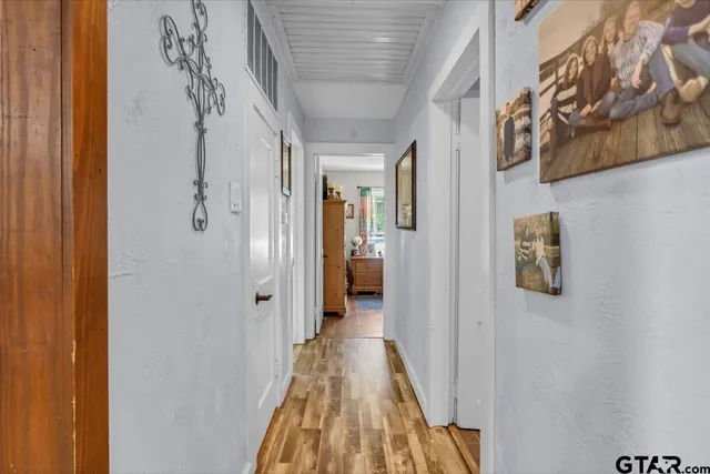 a view of a hallway with wooden floor and closet