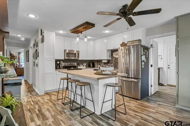 a kitchen with stainless steel appliances granite countertop a refrigerator and a stove top oven
