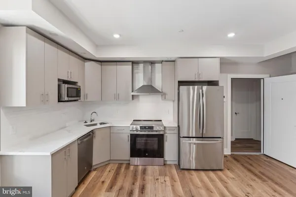 a kitchen with stainless steel appliances a refrigerator sink and microwave