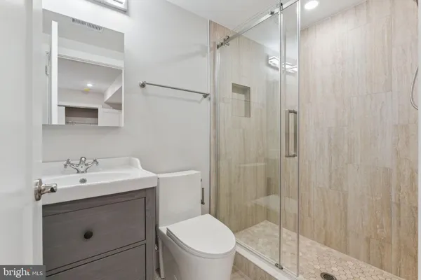 a bathroom with a sink a toilet and shower