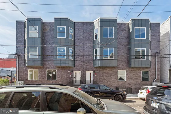 a couple of cars parked in front of a building