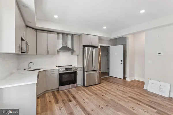 a kitchen with stainless steel appliances granite countertop a refrigerator a sink and a stove