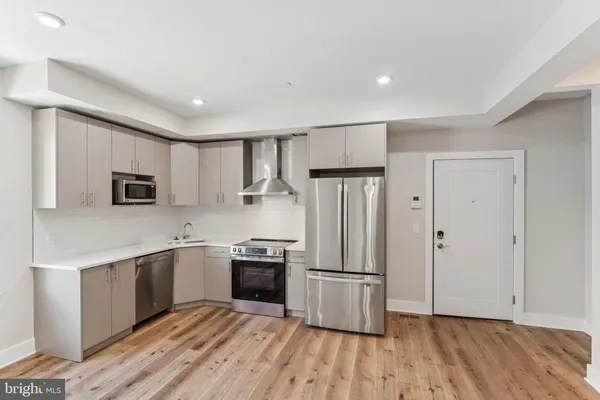a kitchen with stainless steel appliances granite countertop a refrigerator and a stove top oven