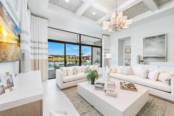 a living room with furniture a chandelier and a large window